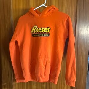 Reese’s bright orange hooded sweatshirt.  Kids size large. Jerzees brand hoodie